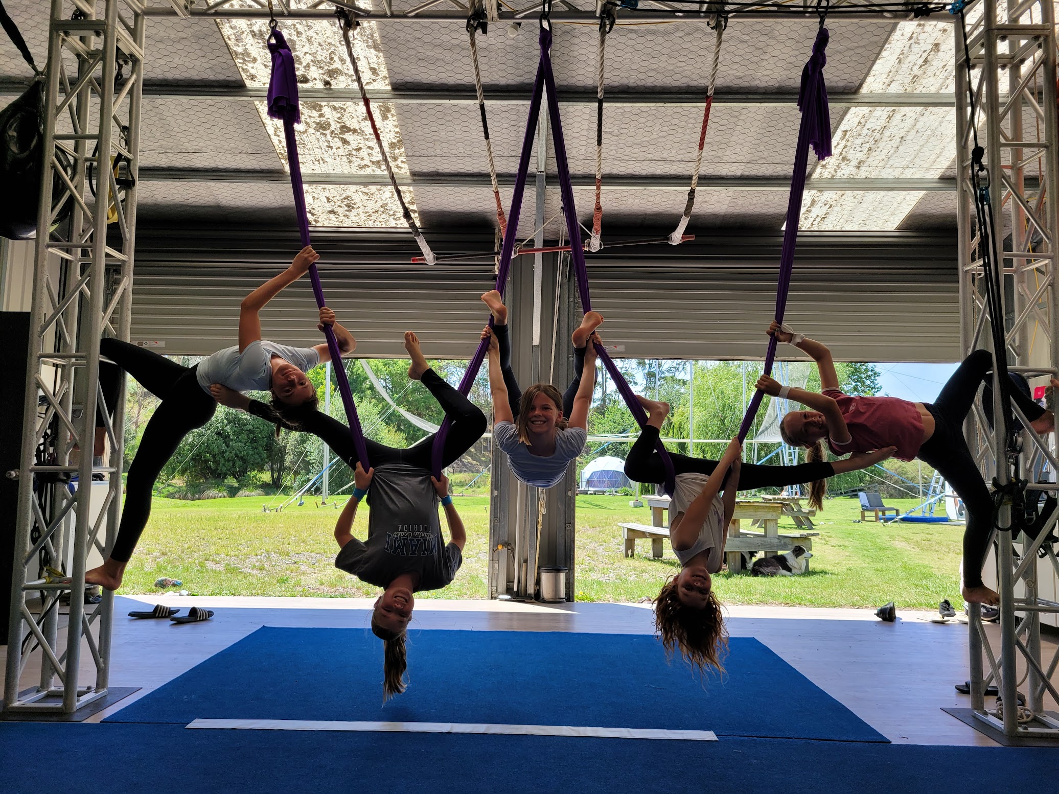 Girls upside down on aerial silks laughing